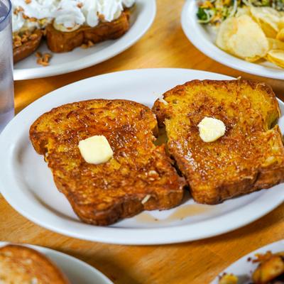 French toast topped with butter and served alongside other dishes.