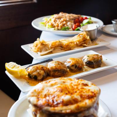 Stuffed mushroom caps, French onion soup, and a salad on a table