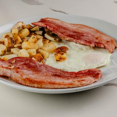 Fried eggs served with bacon and home fries.