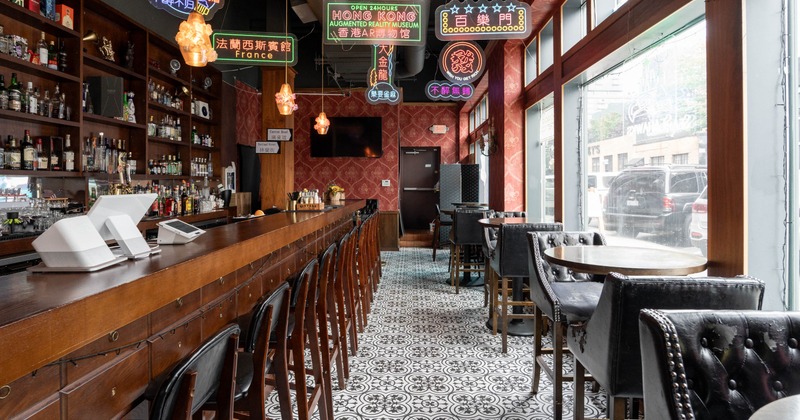 Interior, long wooden counter, liquor shelves, neon signs, patterned tile flooring, leather seating