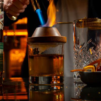 Bartender preparing smoked old fashioned.