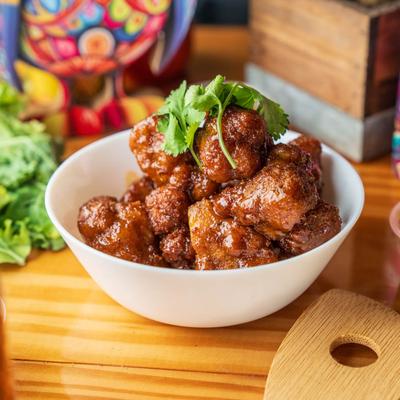 Cauliflower Nuggets served in a white bowl, garnished with parsley.