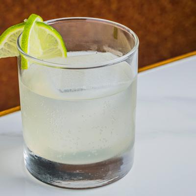 Sparkling Yuzu cocktail garnished with lime slices.