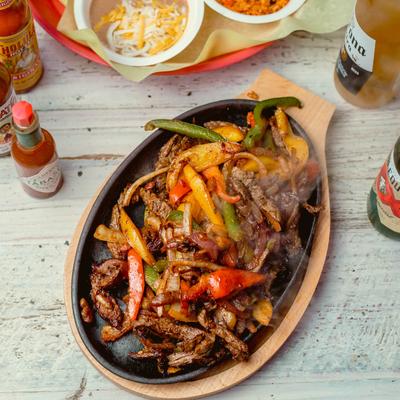 Sizzling skillet of steak fajitas