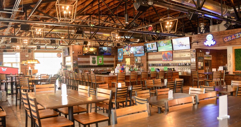 Interior, dining area with tables and chairs and bar in the back