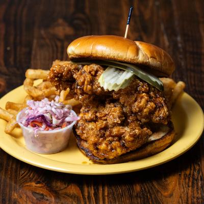 Fried chicken sandwich with coleslaw and fries on the side.