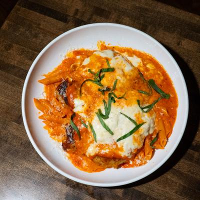 Burrata Chicken Parmesan topped with vodka sauce and basil.