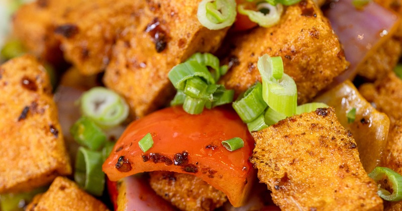 Crispy fried tofu with scallions, peppers, tomatoes, and onions