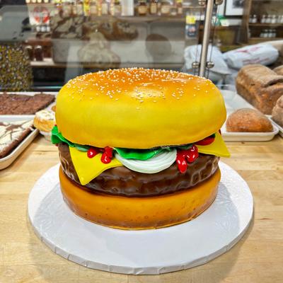 A realistic hamburger-shaped cake on display.