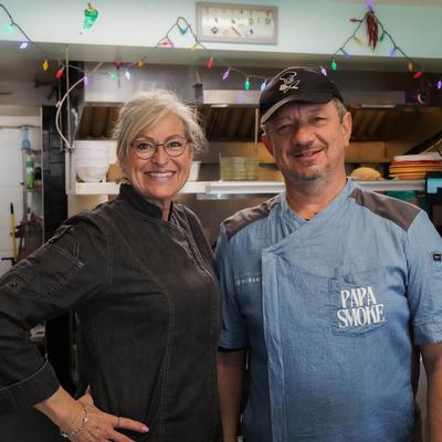 The owner and the chef posing in the kitchen.