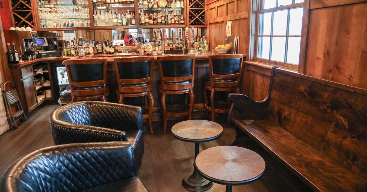 Interior, bar and lounge area, vintage wooden bench with leather armchairs
