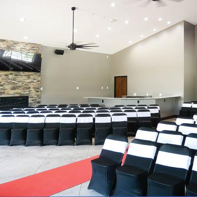 A large event hall, seats and the red carpet isle in the middle.