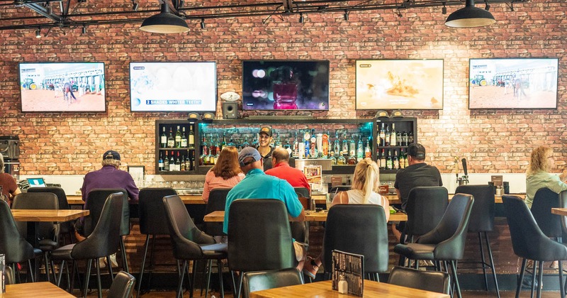 Bar area, bar, guests, bartender, tv screens above