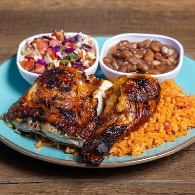 Roasted chicken served with rice, beans and a salad.