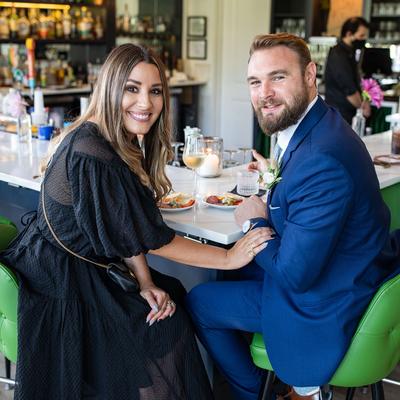A smiling couple sits at the restaurant bar