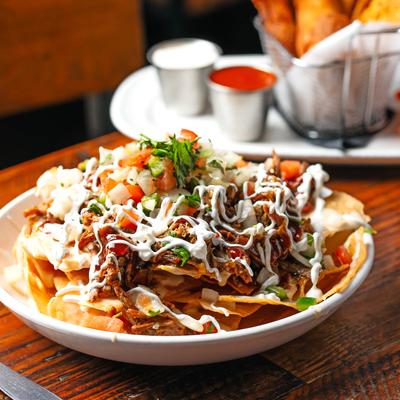 Brisket Nachos with cheese, sour cream, and fresh salsa.