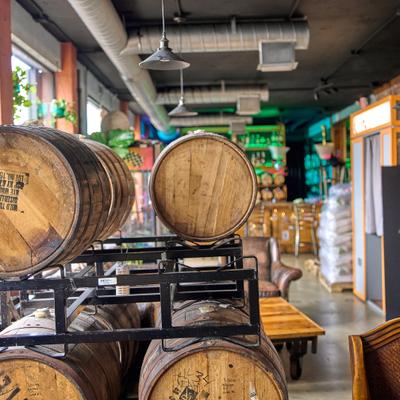Wooden barrels stacked on metal racks inside a brewery.