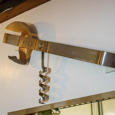 Decorative metal kitchen tool mounted on a wall.