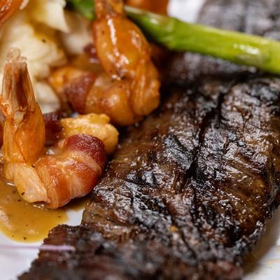 Close-up view of grilled skirt steak and bacon-wrapped jumbo shrimp.