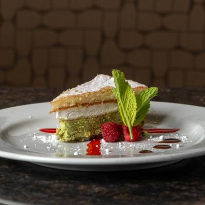 Layered dessert garnished with raspberries and mint.