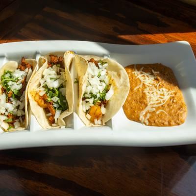 Street tacos served with refried beans.