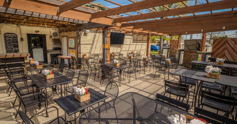 Exterior, patio, covered seating area, regular and high seating tables, exposed wooden beams