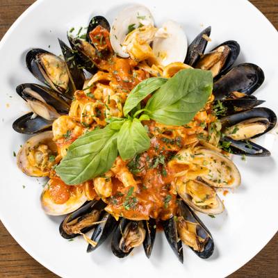Mixed Seafood Linguine served with a red sauce and fresh basil on top.