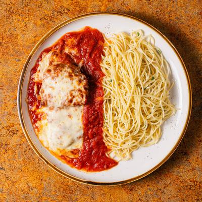 Spaghetti and meatballs in a tomato sauce with cheese.