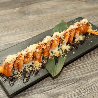 Sushi rolls topped with salmon and tempura flakes.