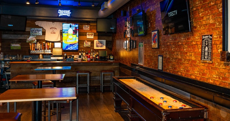 Seating area with Shuffleboard table and a bar in the back