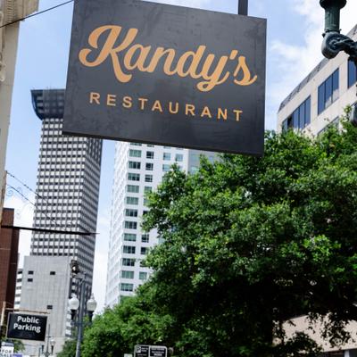 Restaurant's outdoor signage with a view of the street in the background.
