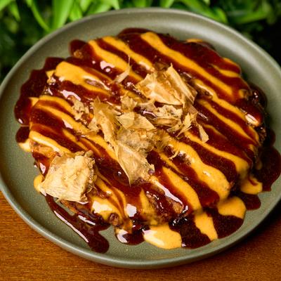 Japanese savory pancake smothered in sauces and topped with bonito flakes.