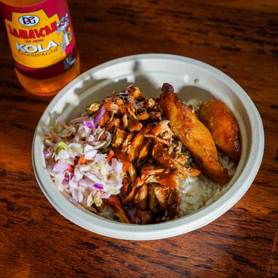 Jerk Chicken Rice Bowl with coleslaw, sweet plantain, and a Jamaican soda.