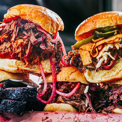 Stacked sandwiches with pulled meat, pickled onions, and jalapenos.