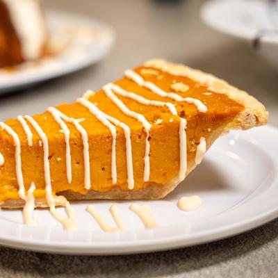 Slice of sweet potato pie drizz;ed with icing.