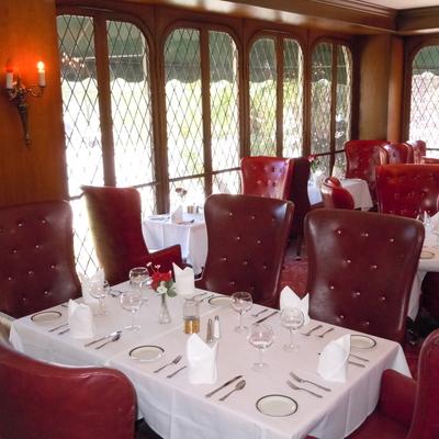 Interior, dining area, tables ready for guests, red leather armchairs.