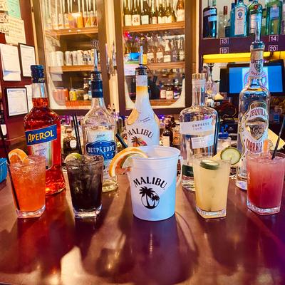 Colorful cocktails and liquor bottles on a bar counter.