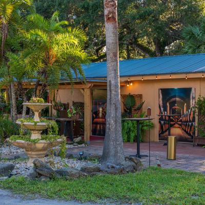 Exterior, a cozy place with a decorative fountain, plants, and trees in front.