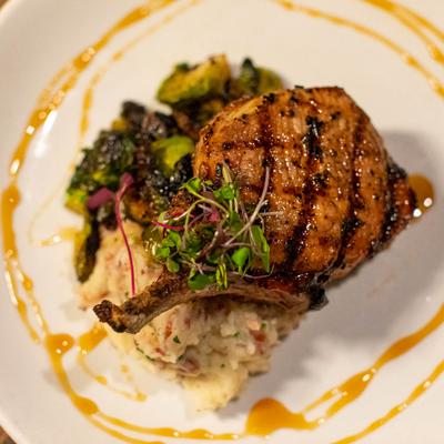 Grilled Pork Chop, mashed potatoes, and caramelized brussels sprouts.