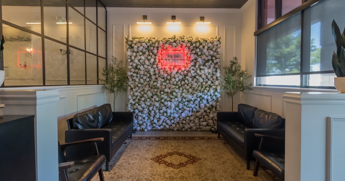 Black leather sofas by the flower wall