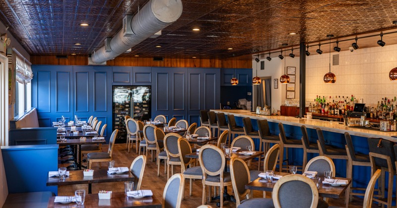 Interior, dining and bar area, tables for four, banquette seating with tables and chairs
