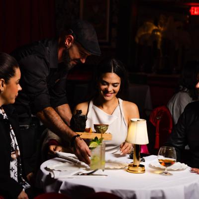 Server assisting guests at their table in the dining room.