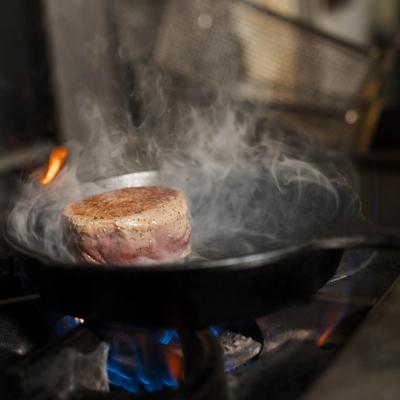 Filet Mignon searing on a pan.