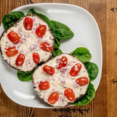 Whitefish salad sandwich featuring cherry tomatoes, diced red onions and fresh spinach.