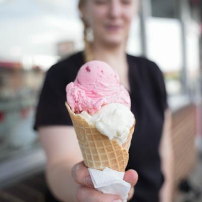 staff member holding double dip ice cream cone.