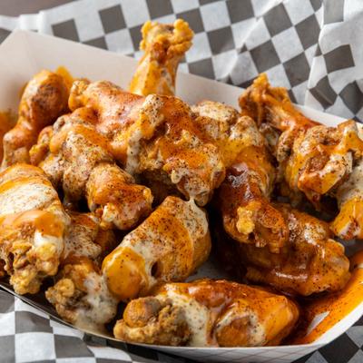 Fried chicken wings drizzled with peppered ranch and spicy sauces.