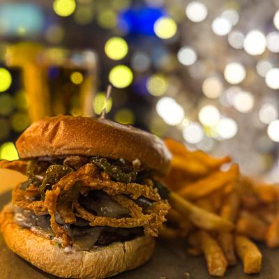 A Jalapeno Burger. Double Angus pepperjack cheeseburger with fried jalapenos and onion strings with a side of fries..