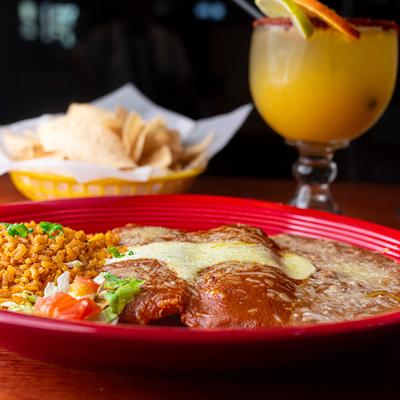 Chicken Tamales, with enchilada sauce, rice and refried beans.
