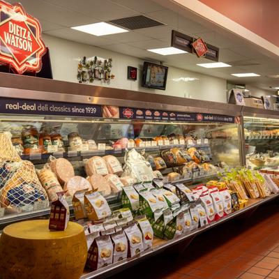 Deli counter with assorted meats, cheeses, and packaged snacks.