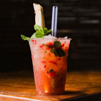 Strawberry Margarita in a plastic glass, served on a table.